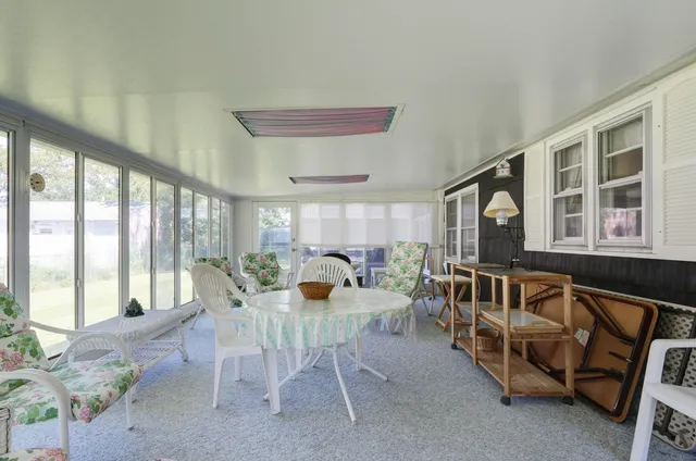 a dining room with furniture and a large window