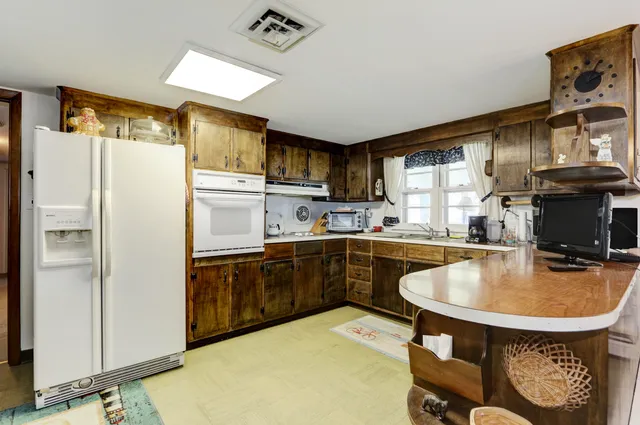 a kitchen with kitchen island a sink appliances and cabinets