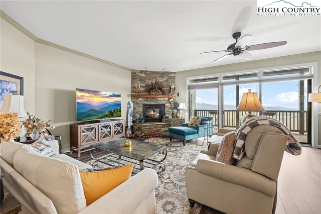 a living room with furniture a flat screen tv and a floor to ceiling window