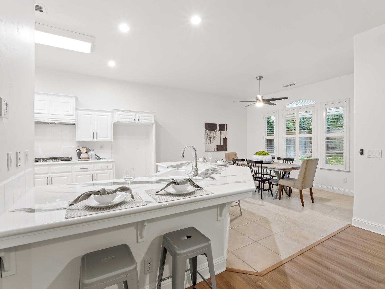 8683 North Richelle Avenue Fresno, CA 93720 - Photo 7 of 44 a kitchen with a dining table chairs and white cabinets
