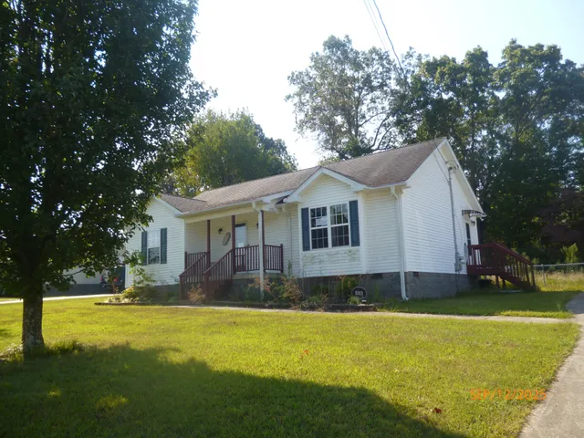 a front view of house with yard and swimming pool