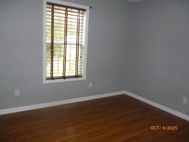 a view of a room with wooden floor and windows in it