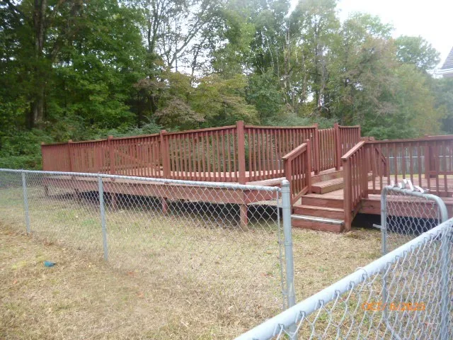a view of a roof deck with wooden fence and a floor to ceiling window