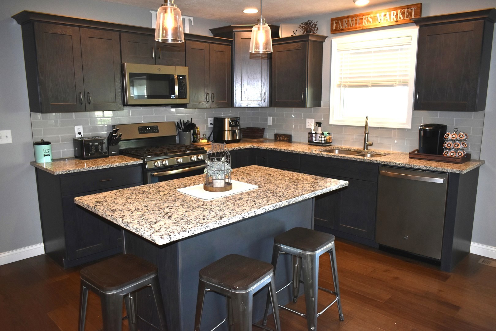 13 Wolf Run Road El Paso, IL 61738 - Photo 22 of 57 a kitchen with kitchen island granite countertop a sink chairs and microwave