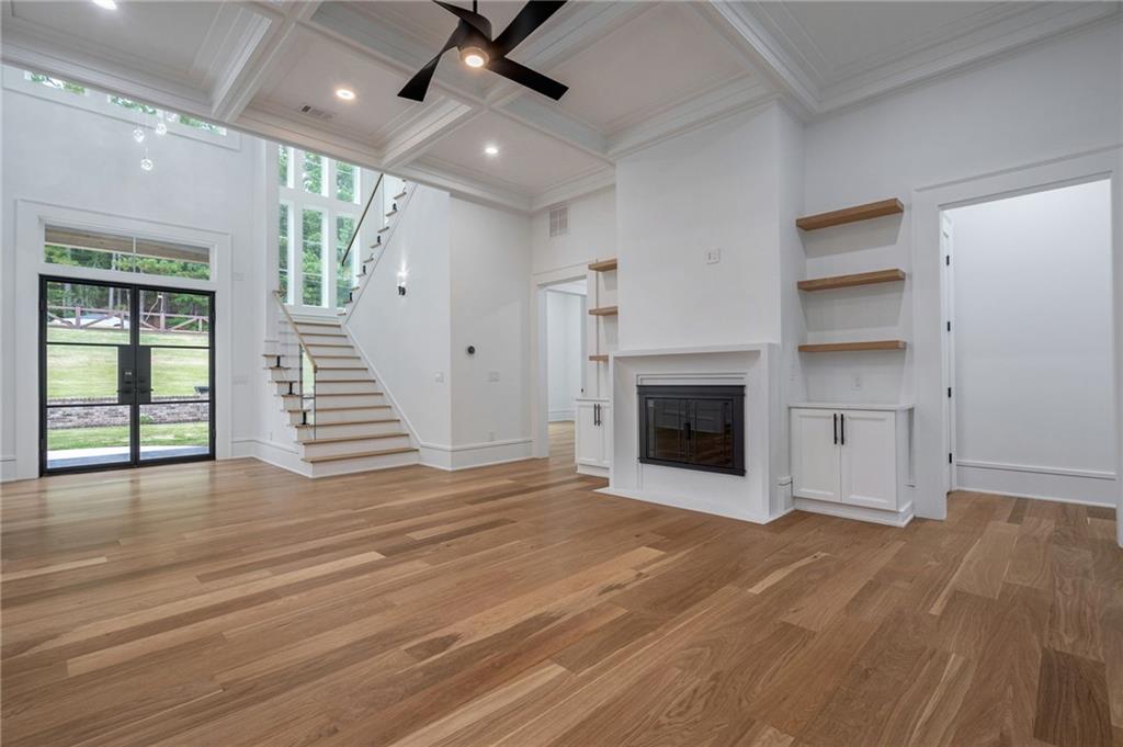 4459 Grady Smith Road Loganville, GA 30052 - Photo 3 of 124 an empty room with wooden floor a ceiling fan front door and windows