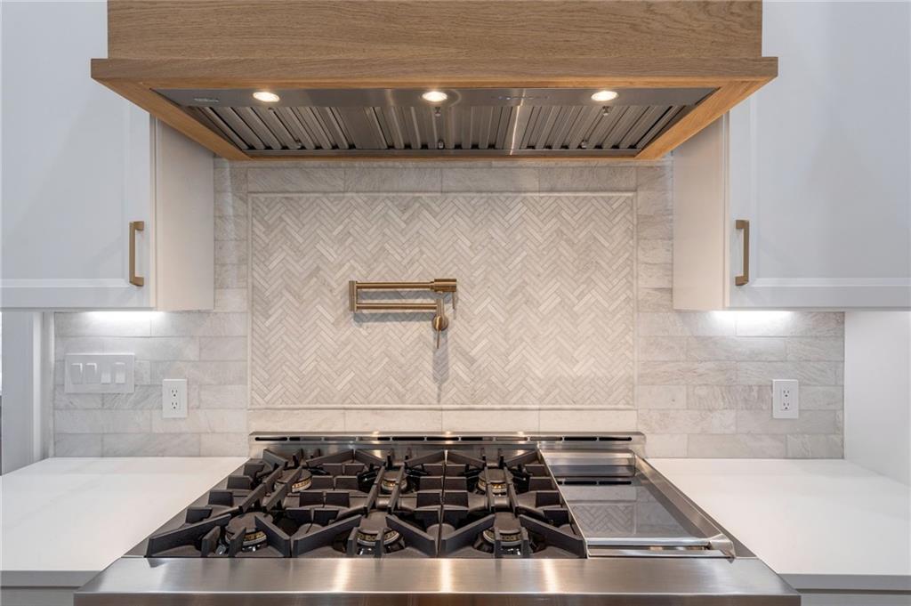 4459 Grady Smith Road Loganville, GA 30052 - Photo 35 of 124 a sink sitting inside of a kitchen with granite countertop stainless steel appliances