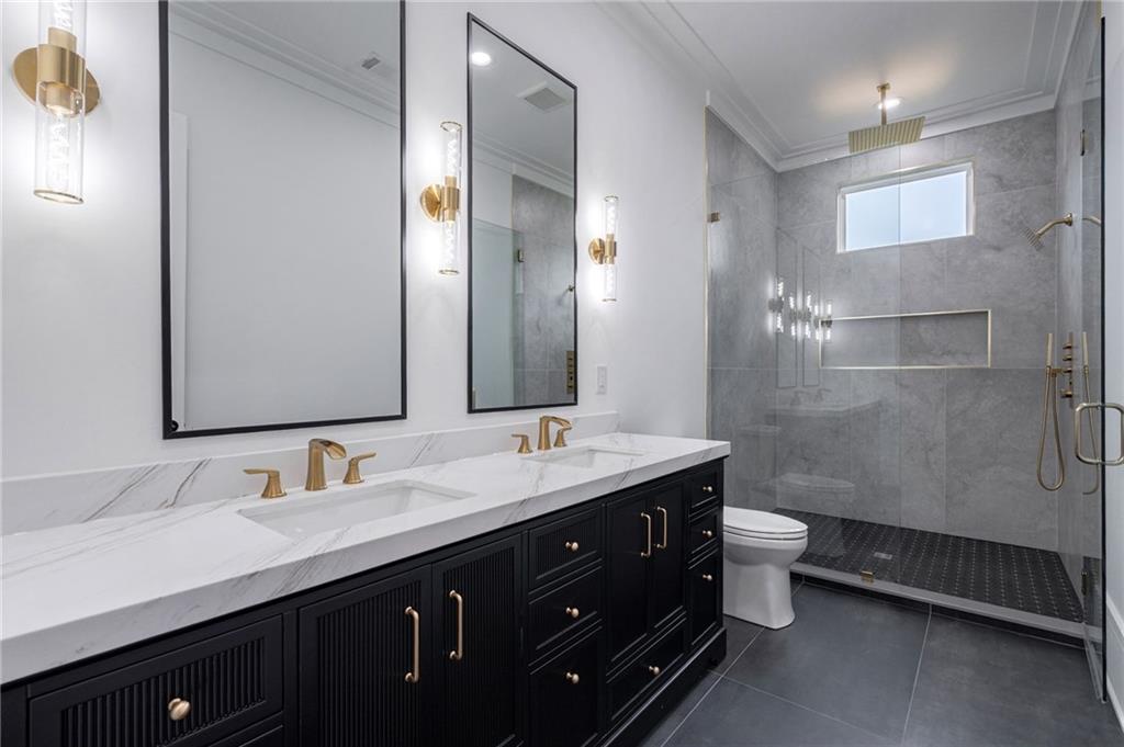 4459 Grady Smith Road Loganville, GA 30052 - Photo 8 of 124 a bathroom with a double vanity sink toilet and a mirror