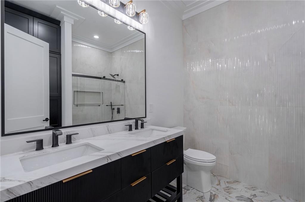 4459 Grady Smith Road Loganville, GA 30052 - Photo 85 of 124 a bathroom with a sink a toilet a mirror and shower