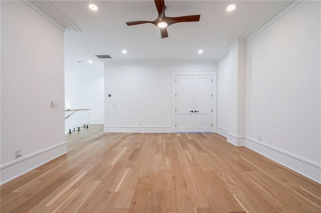 4459 Grady Smith Road Loganville, GA 30052 - Photo 93 of 124 an empty room with wooden floor and a ceiling fan