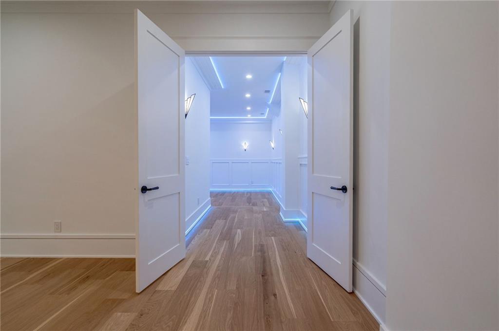 4459 Grady Smith Road Loganville, GA 30052 - Photo 100 of 124 a view of a hallway with wooden floor and a bathroom