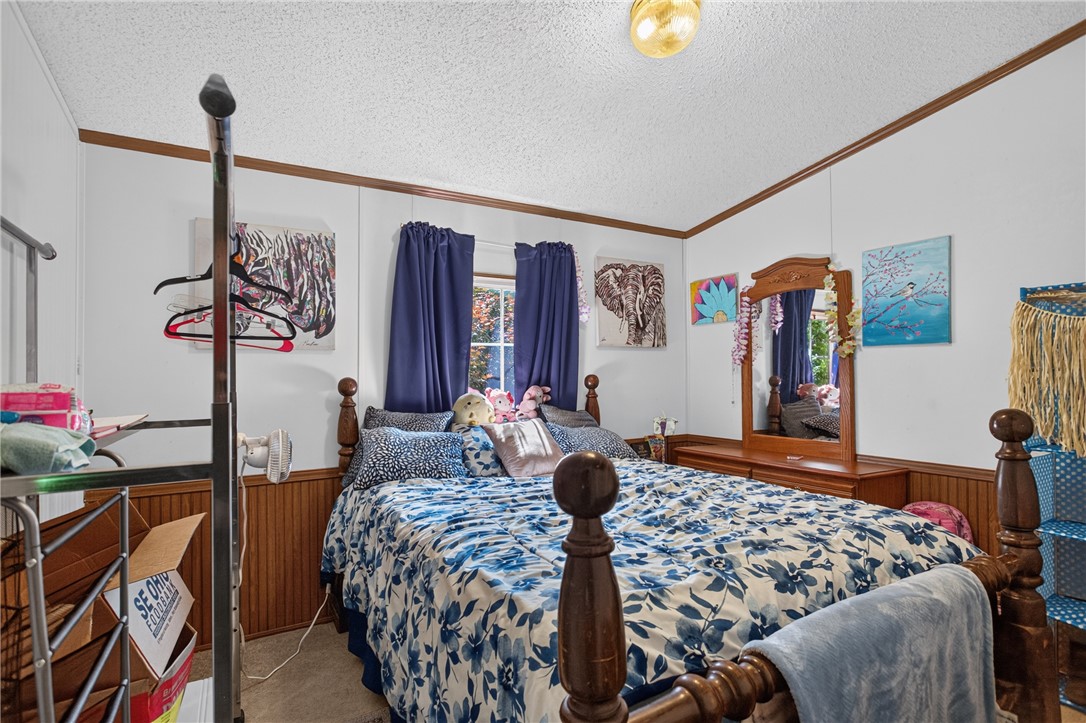 418 Chauga Road Westminster, SC 29693 - Photo 21 of 38 A well-lit bedroom provides a cozy retreat, featuring classic wooden trim and a clear window for natural light.