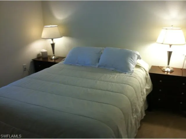 a bedroom with a bed and a lamp