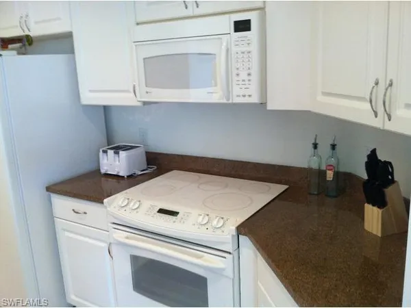 a kitchen with a stove and a white cabinet