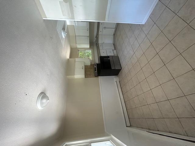 67 Johns Neck Road Shirley, NY 11967 - Photo 3 of 7 an empty room with fireplace and windows