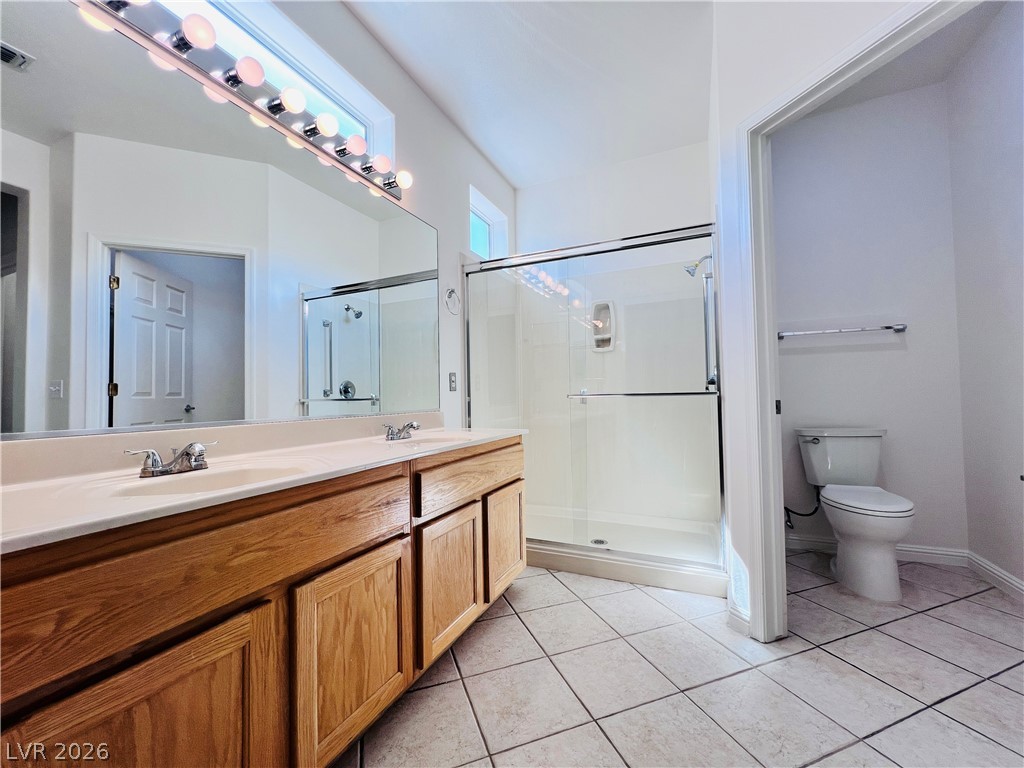 3047 Hickory Valley Road Henderson, NV 89052 - Photo 15 of 33 A well-lit bathroom features a spacious dual vanity and a walk-in shower.