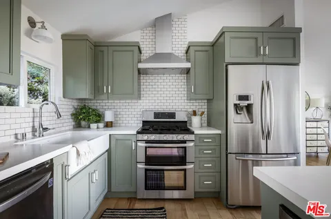a kitchen with cabinets a stainless steel appliances and refrigerator