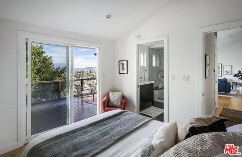 a bedroom with furniture and large windows