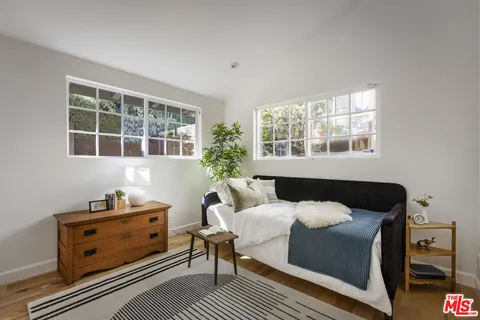 a bedroom with a bed and windows