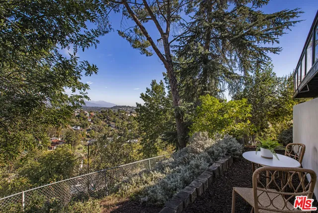 a view of backyard with seating space and trees