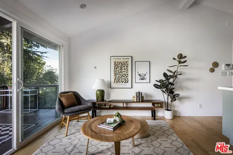 a living room with furniture a table and a potted plant