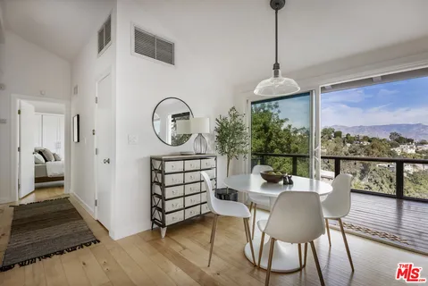 a dining room with furniture a chandelier and wooden floor