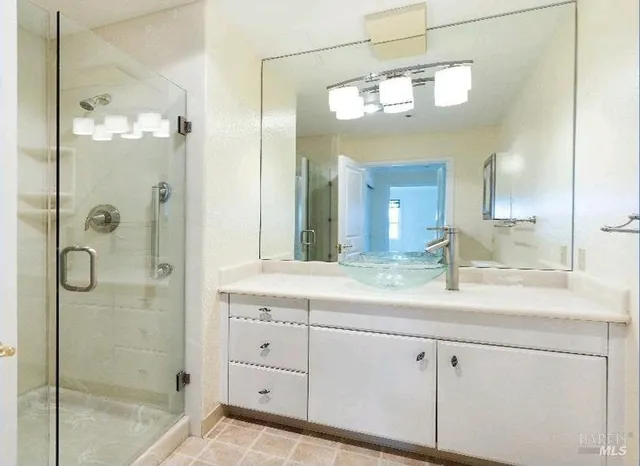 a bathroom with a granite countertop shower sink and mirror