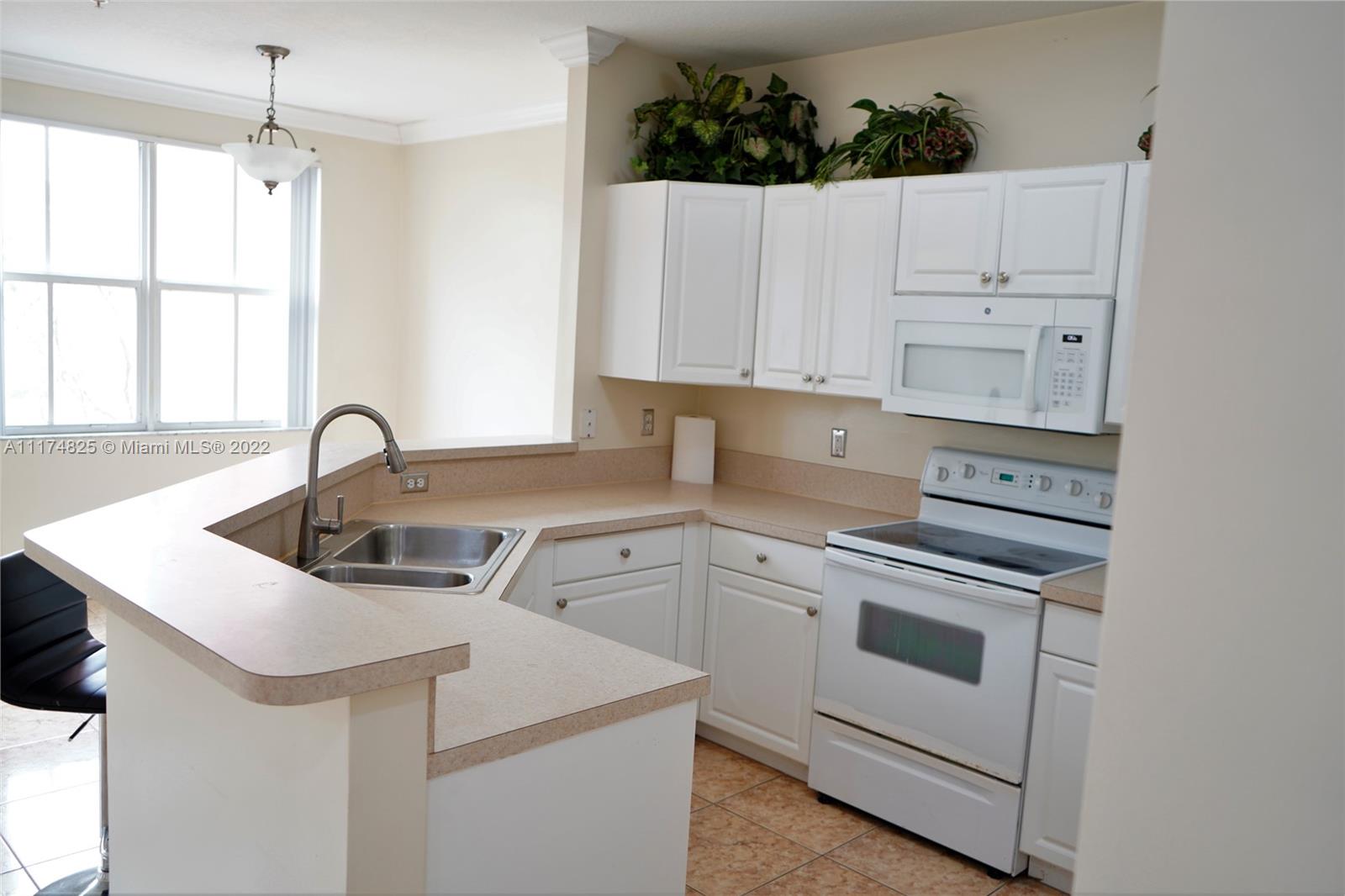 4402 Southwest 160th Avenue, Unit 925 Miramar, FL 33027 - Photo 4 of 34 a kitchen with white cabinets sink and stove