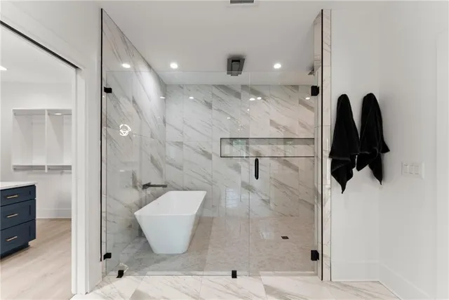 a view of an empty room with a window and kitchen view