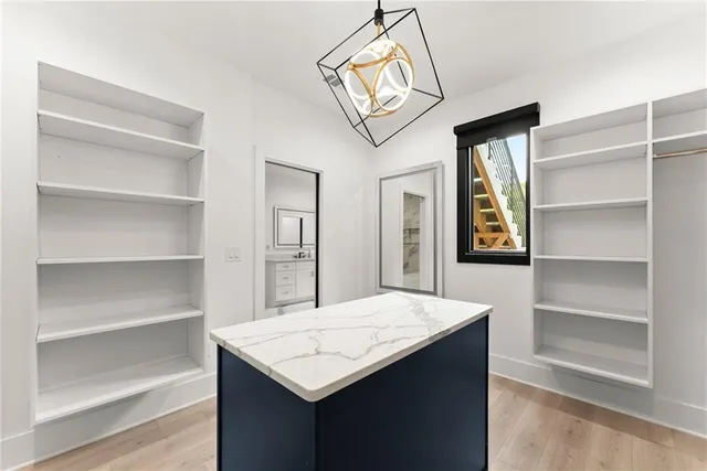 a large kitchen with kitchen island a large counter top space a sink stainless steel appliances and cabinets