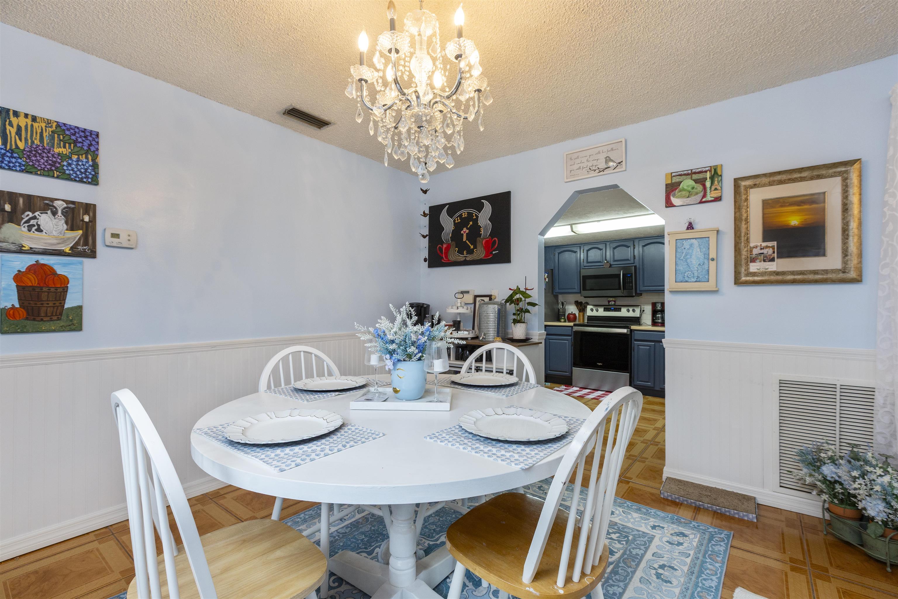 4240 New Hampshire Road Elkton, FL 32033 - Photo 21 of 35 a view of a dining room with furniture a chandelier and wooden floor