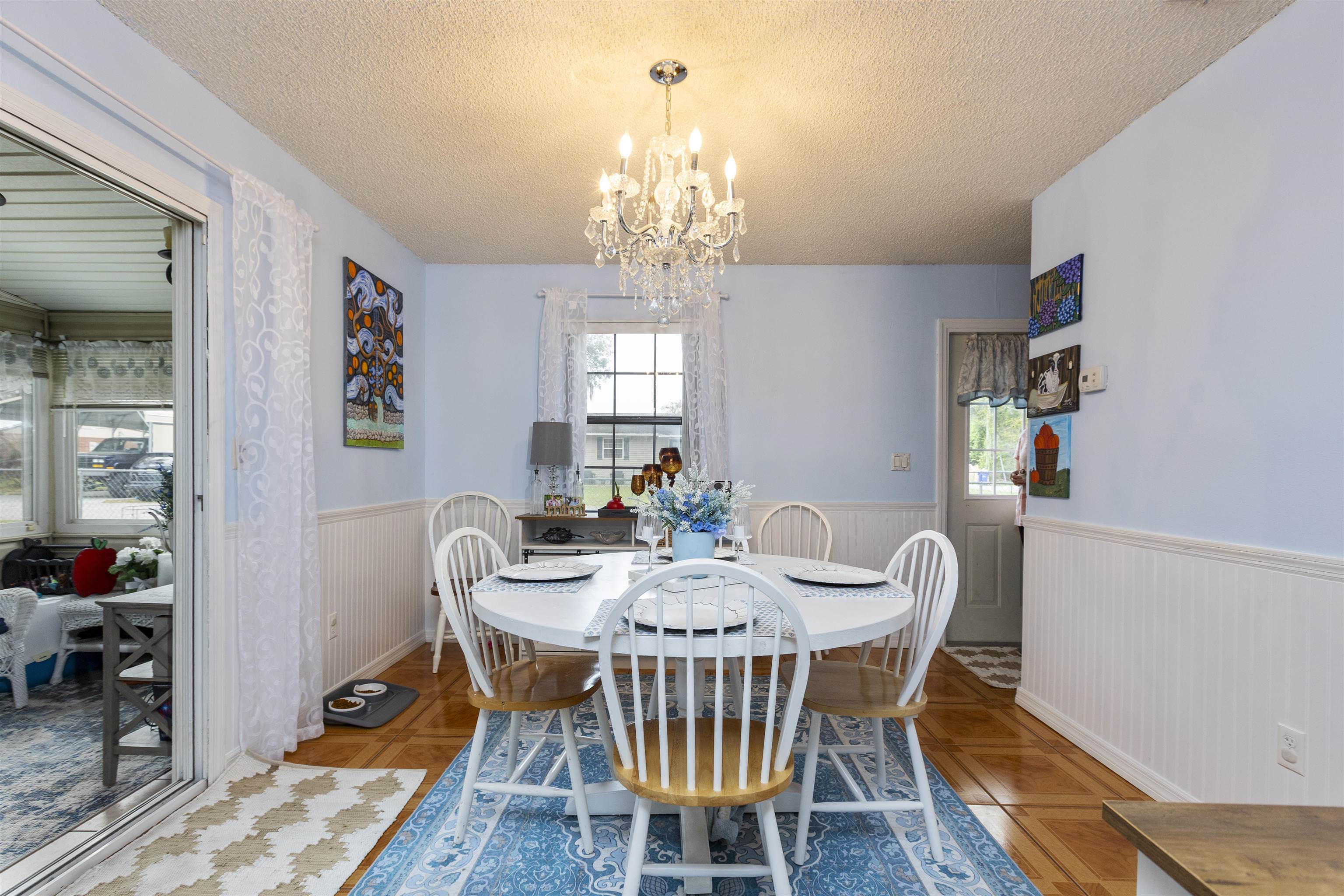 4240 New Hampshire Road Elkton, FL 32033 - Photo 22 of 35 a view of a dining room with furniture a chandelier and wooden floor