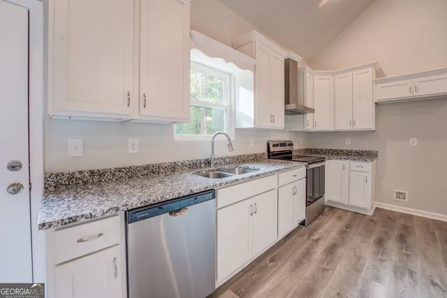 a kitchen with granite countertop white cabinets and white appliances