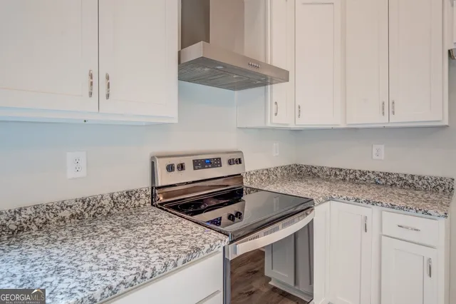 a kitchen with a stove and a white cabinets