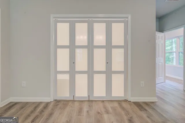 an empty room with wooden floor and windows