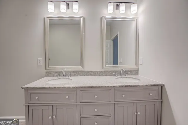 a bathroom with double sink and a mirror