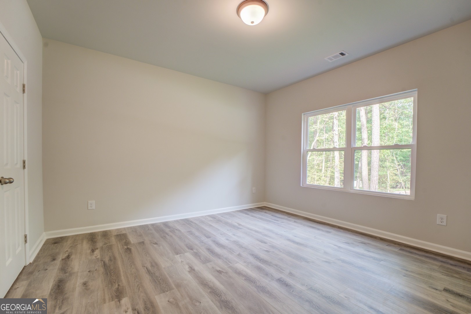 359 Whippoorwill Road Monticello, GA 31064 - Photo 37 of 37 an empty room with wooden floor and windows