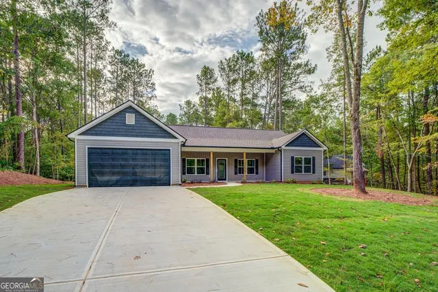 a front view of a house with a yard and trees