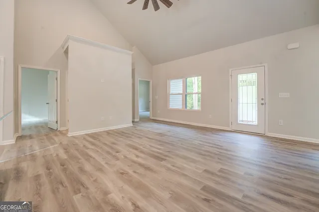 an empty room with wooden floor and windows