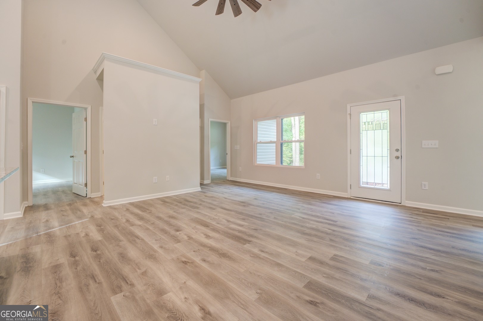 359 Whippoorwill Road Monticello, GA 31064 - Photo 7 of 37 an empty room with wooden floor and windows
