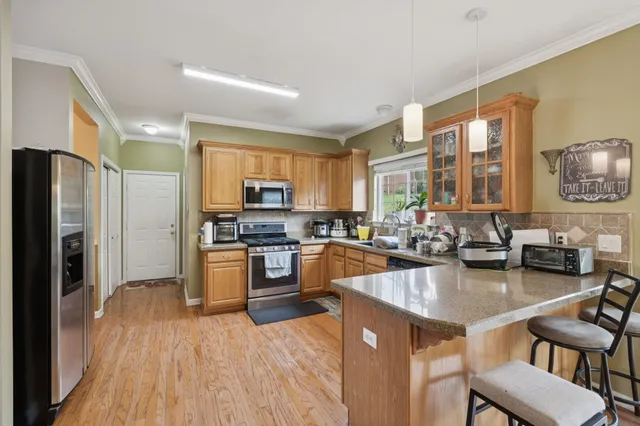 a kitchen with a refrigerator a stove top oven a sink dishwasher and cabinets with wooden floor