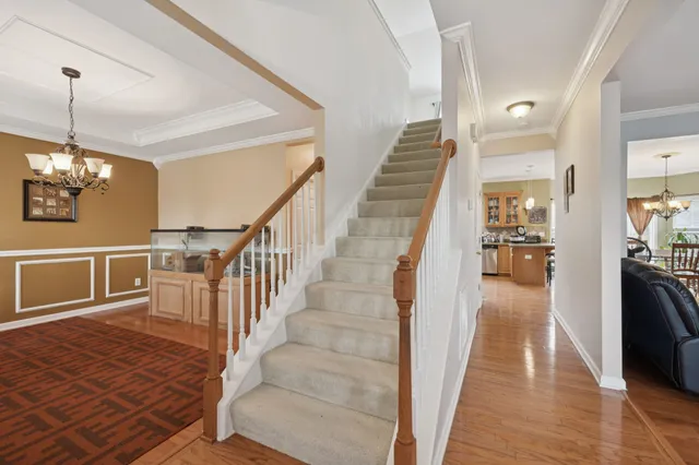 a view of a hallway with wooden floor and staircase