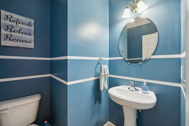 a bathroom with a sink mirror and toilet
