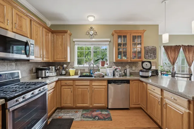 a kitchen with stainless steel appliances granite countertop a stove sink and cabinets