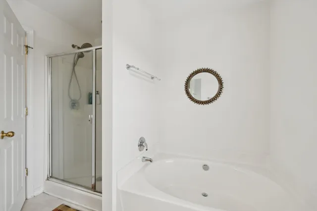 a white bath tub sitting next to a shower