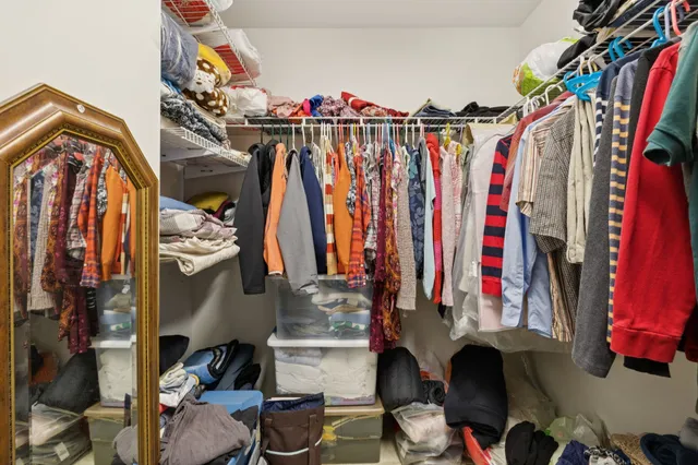 a view of walk in closet with clothes and shoes