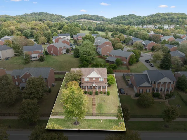 an aerial view of residential houses with outdoor space and street view