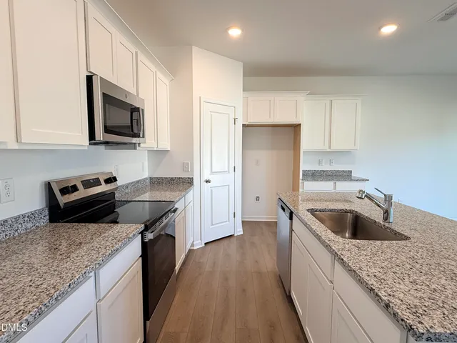 a kitchen with granite countertop a sink and a stove top oven