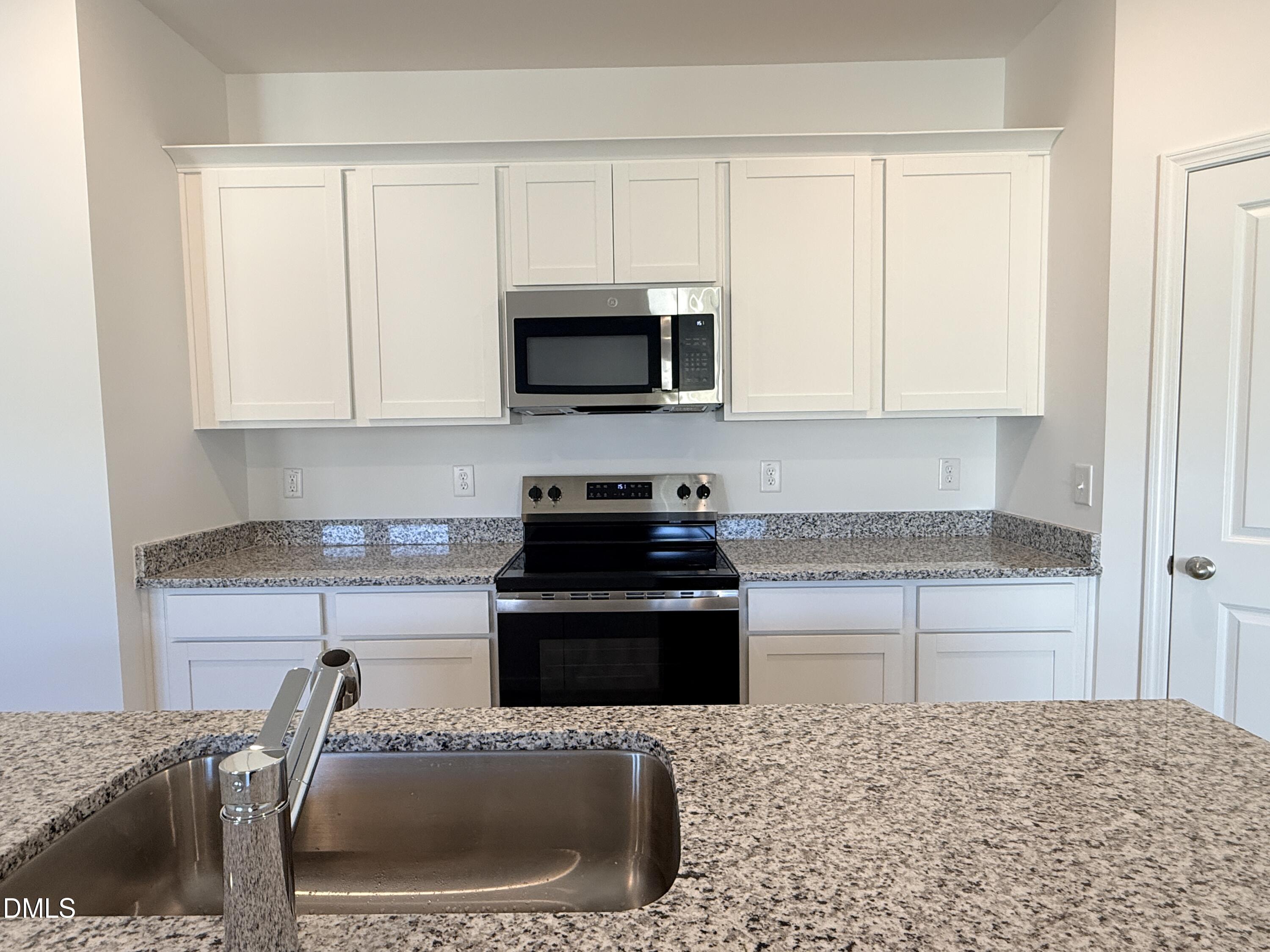 11790 Salers Loop Middlesex, NC 27557 - Photo 36 of 43 a kitchen with granite countertop a stove a sink and a microwave