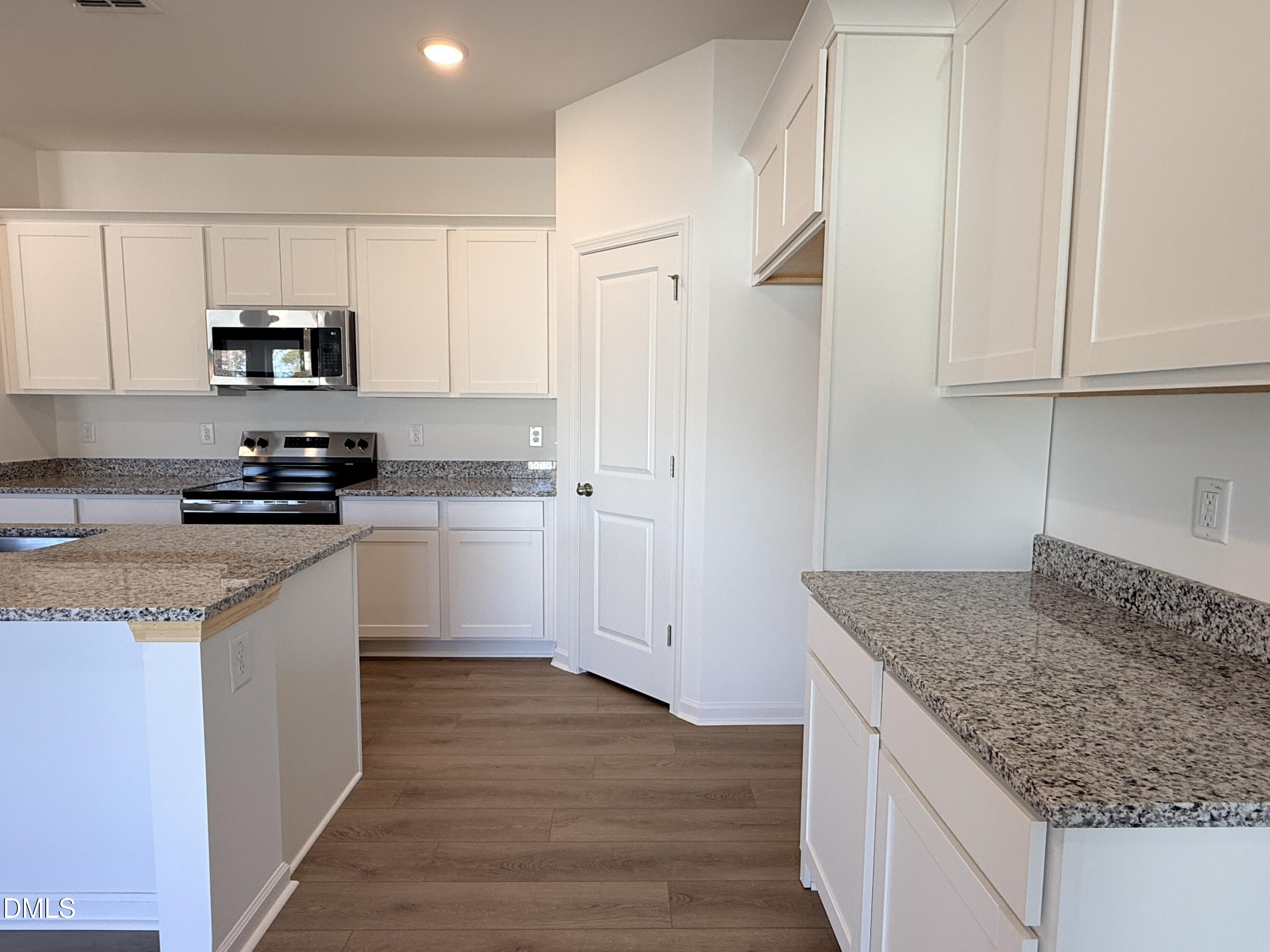 11790 Salers Loop Middlesex, NC 27557 - Photo 40 of 43 a kitchen with granite countertop a sink and a stove top oven