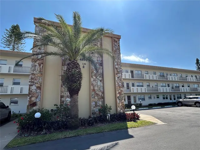 a view of a building with a garden and pathway